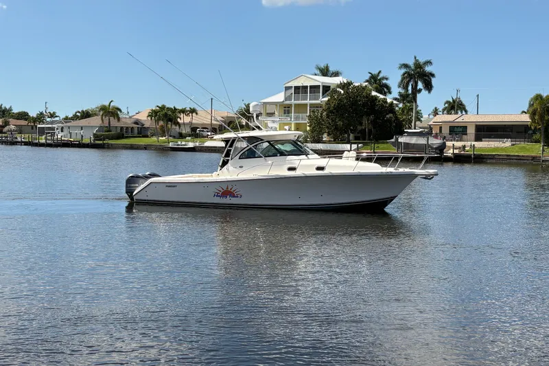 Slide: The Image of 2011 Pursuit OS 375 Offshore boat on calm water, surrounded by waterfront homes and palm trees. - 3
