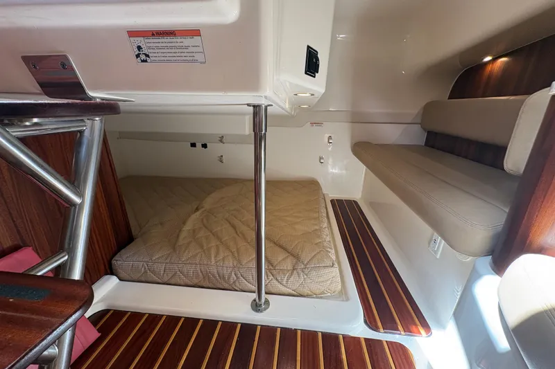 Slide: The Image of 2011 Pursuit OS 375 Offshore cabin interior with wood accents and cushioned seating. - 35