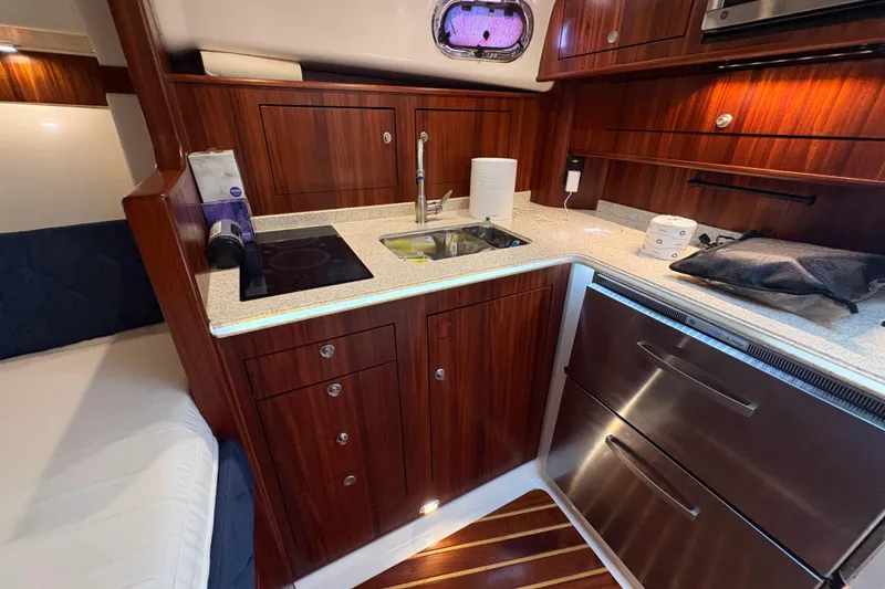 Slide: The Image of Luxurious 2011 Pursuit OS 375 Offshore yacht kitchen with wood cabinetry and modern appliances. - 42