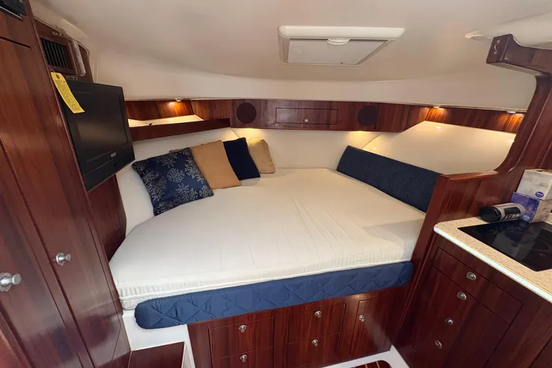 Slide: The Image of Luxurious cabin interior of 2011 Pursuit OS 375 Offshore boat with cozy bedding. - 43