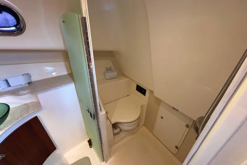 Slide: The Image of 2011 Pursuit OS 375 Offshore boat bathroom with compact toilet and storage. - 48