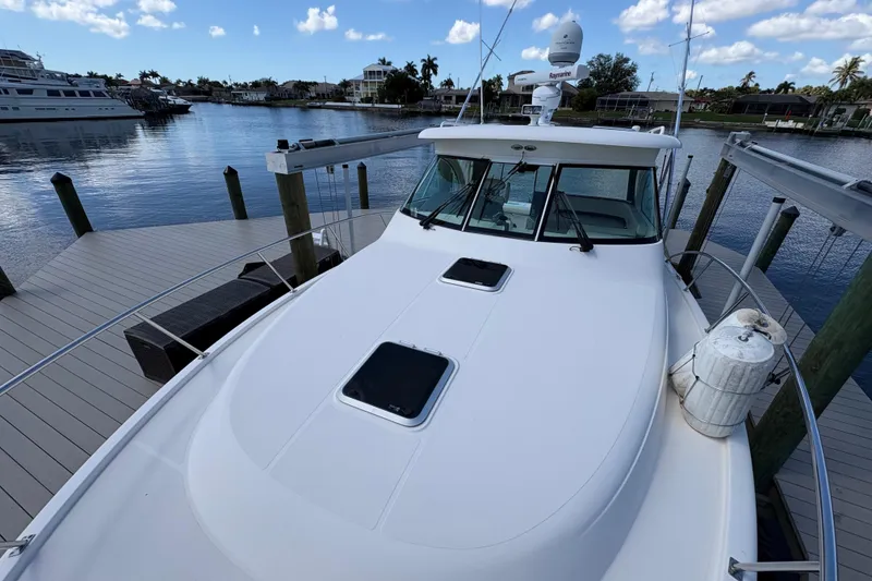 Slide: The Image of 2011 Pursuit OS 375 Offshore boat docked at marina under blue sky. - 9