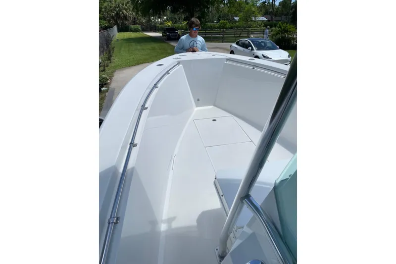 Slide: The Image of 1995 Contender 21 CC boat with spacious deck, parked outdoors. - 3