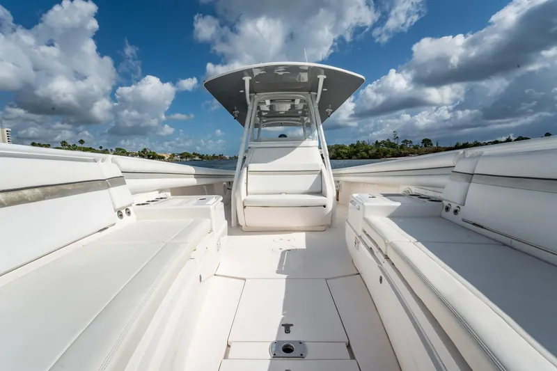 Slide: The Image of 2015 Intrepid 375 Center Console boat interior with white seating under a blue sky. - 13