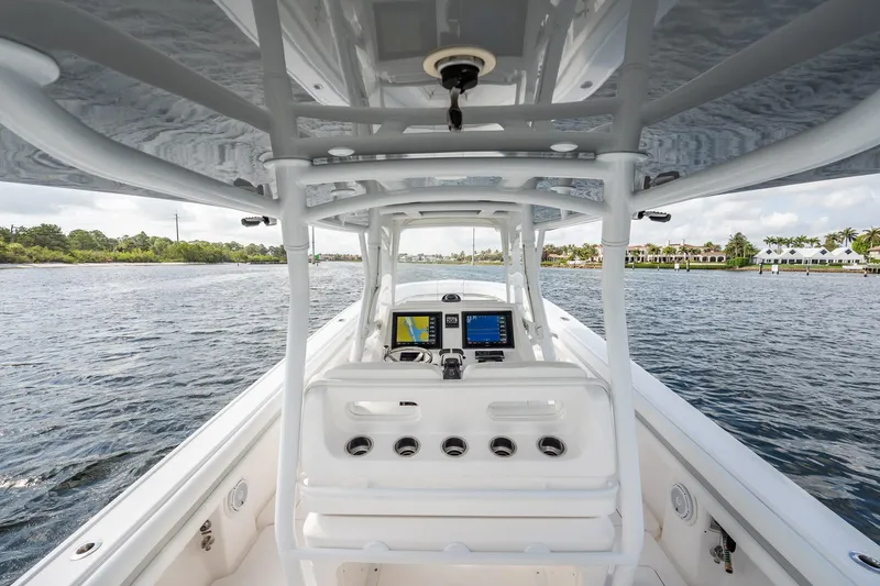 Slide: The Image of 2015 Intrepid 375 Center Console boat interior with navigation equipment on a calm waterway. - 16