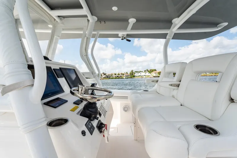 Slide: The Image of Interior view of 2015 Intrepid 375 Center Console boat with white seating and control panel. - 19