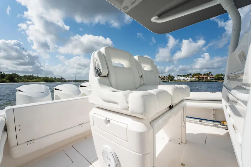 Slide: The Image of 2015 Intrepid 375 Center Console boat interior with white seating and scenic water view. - 9