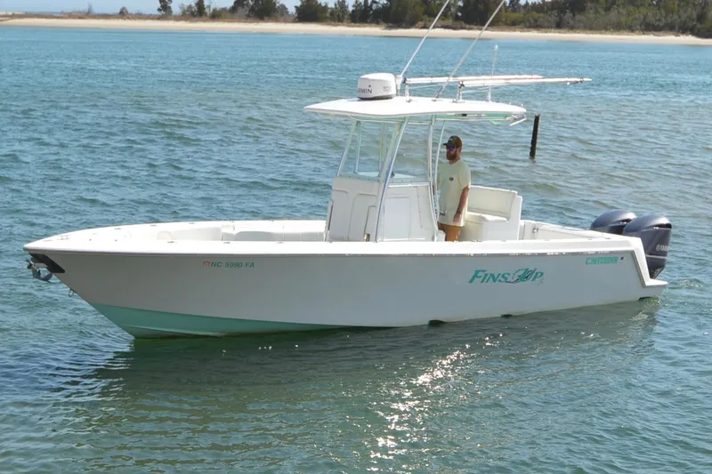 The Image of 2015 Contender 32 ST boat on water with person onboard, featuring twin Yamaha engines. - 0