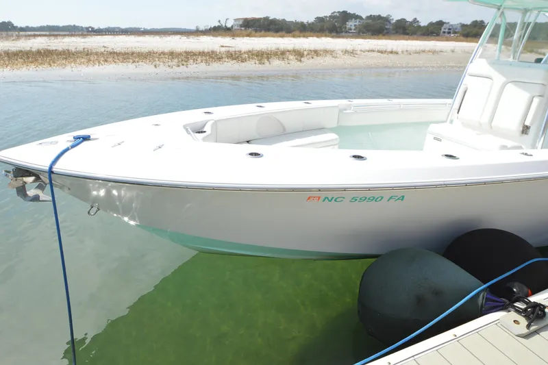 Slide: The Image of 2015 Contender 32 ST boat docked in clear water near sandy shore. - 10