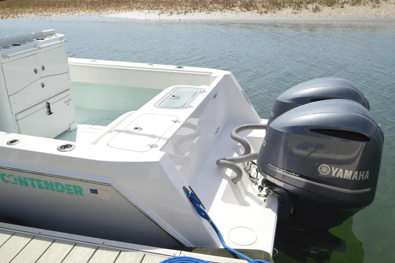 Slide: The Image of 2015 Contender 32 ST boat with dual Yamaha outboard motors docked by the water. - 14