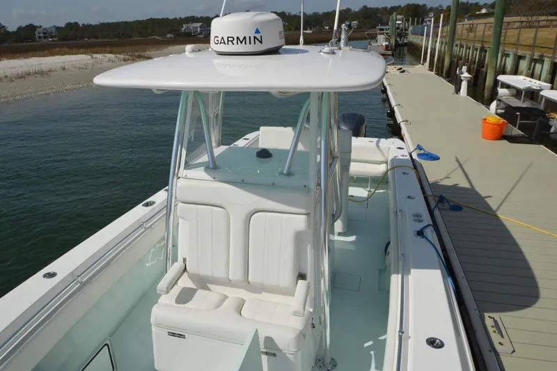 Slide: The Image of 2015 Contender 32 ST boat docked, featuring Garmin equipment and sleek white seating. - 19