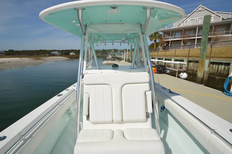 Slide: The Image of 2015 Contender 32 ST boat docked, featuring white seating and a sleek design. - 2