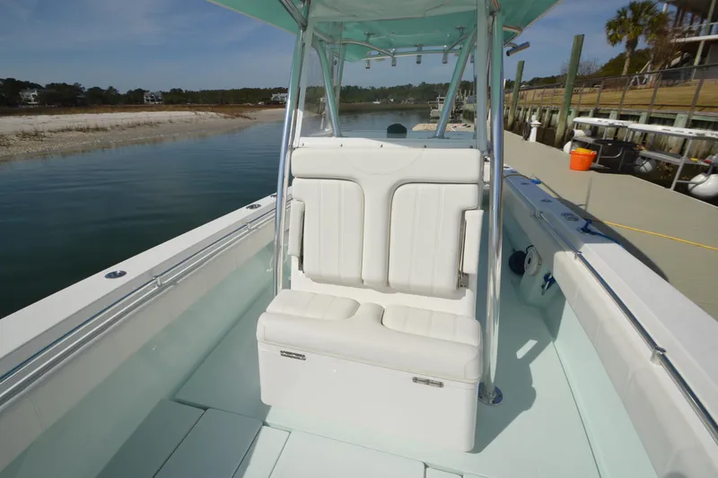 Slide: The Image of 2015 Contender 32 ST boat with white seating, docked by a calm waterfront. - 20