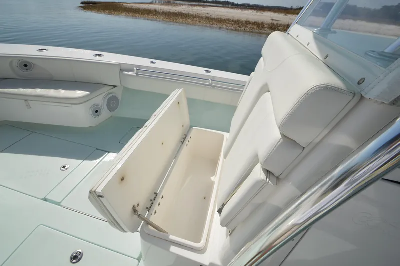 Slide: The Image of 2015 Contender 32 ST boat interior with open storage compartment, white seating, and ocean view. - 21