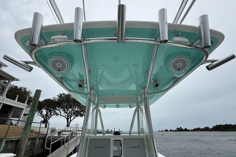 Slide: The Image of 2015 Contender 32 ST boat with teal canopy and mounted speakers at dock. - 23