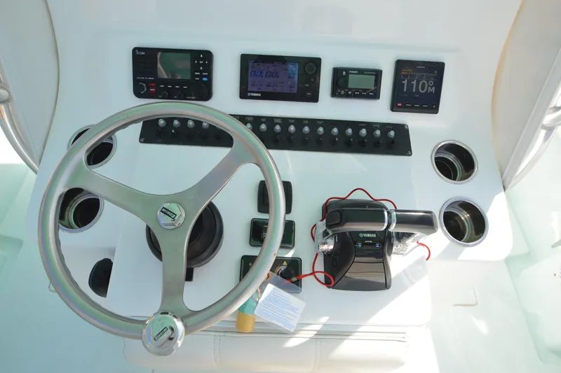 Slide: The Image of Control panel of a 2015 Contender 32 ST boat with steering wheel and instruments. - 25