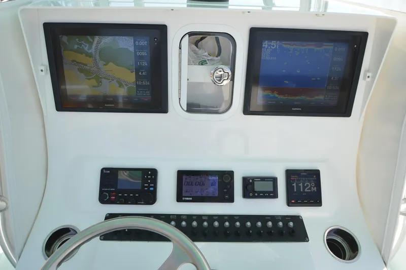 Slide: The Image of Control panel of a 2015 Contender 32 ST boat with navigation screens and instruments. - 26