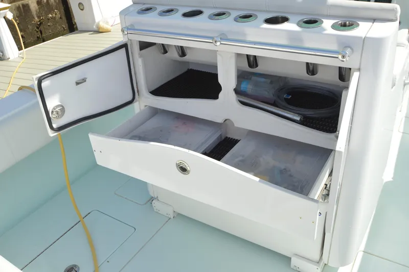 Slide: The Image of 2015 Contender 32 ST boat storage compartments with open drawers and fishing gear. - 27
