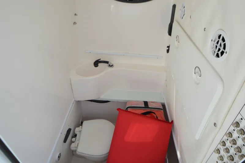 Slide: The Image of 2015 Contender 32 ST boat interior with sink, toilet, and storage compartment. - 32