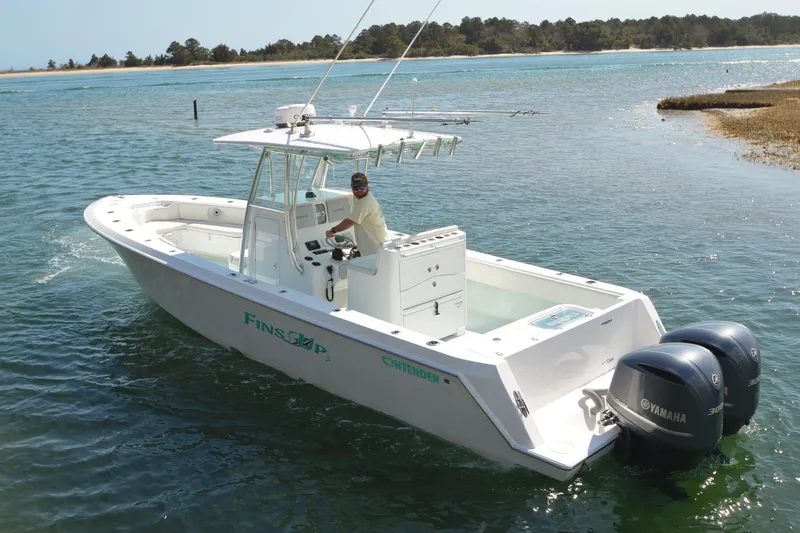 Slide: The Image of 2015 Contender 32 ST boat with dual Yamaha engines on a scenic waterway. - 4