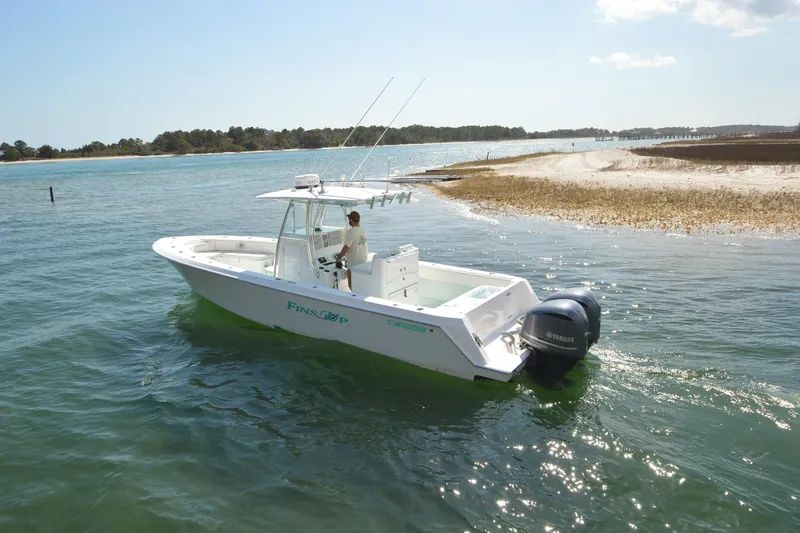 Slide: The Image of 2015 Contender 32 ST boat cruising near sandy shoreline with dual Yamaha engines. - 6
