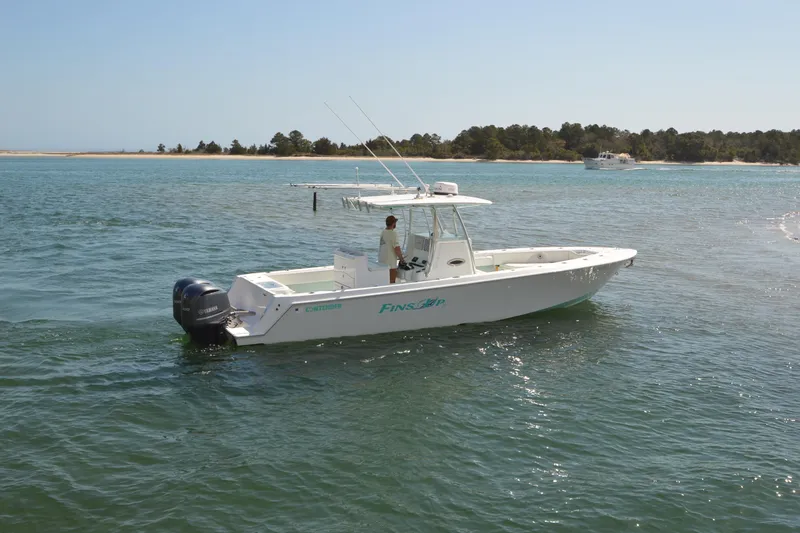 Slide: The Image of 2015 Contender 32 ST boat on water with Yamaha engines, near shoreline. - 8