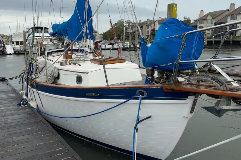 The Image of 1977 Pacific Seacraft 31 sailboat docked at marina, featuring blue and white design. - 0