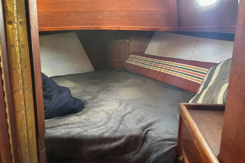 Slide: The Image of Cozy cabin interior of a 1977 Pacific Seacraft 31 sailboat with striped cushions. - 10