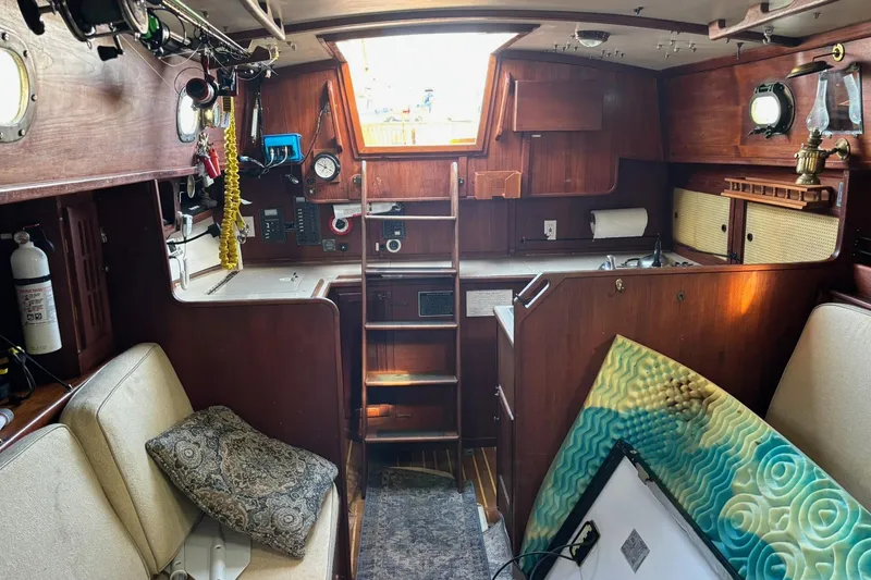 Slide: The Image of Interior of a 1977 Pacific Seacraft 31 sailboat with wooden cabinetry and seating. - 11