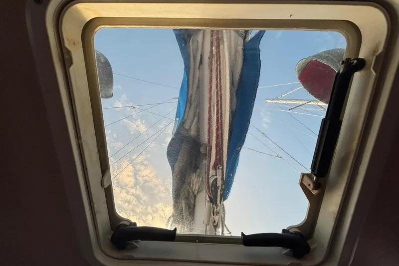 Slide: The Image of View through a Pacific Seacraft 31 hatch, showing mast and rigging against a blue sky. - 12