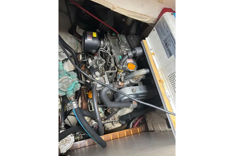 Slide: The Image of Engine compartment of a 1977 Pacific Seacraft 31 sailboat, showcasing mechanical components. - 18