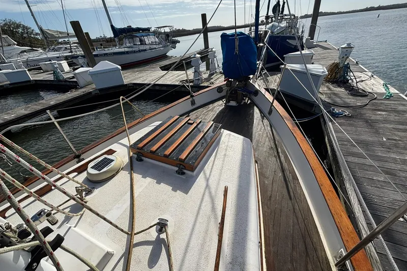 Slide: The Image of 1977 Pacific Seacraft 31 sailboat docked at marina, showcasing deck and rigging. - 2