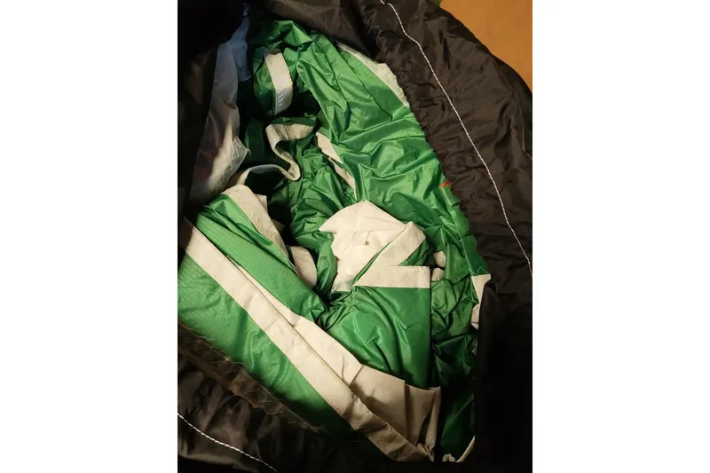 Slide: The Image of Green and white sail fabric from a 1977 Pacific Seacraft 31, folded in a black bag. - 20