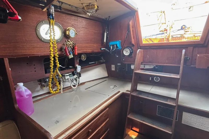 Slide: The Image of Interior of a 1977 Pacific Seacraft 31 sailboat with wooden cabinetry and navigation equipment. - 6