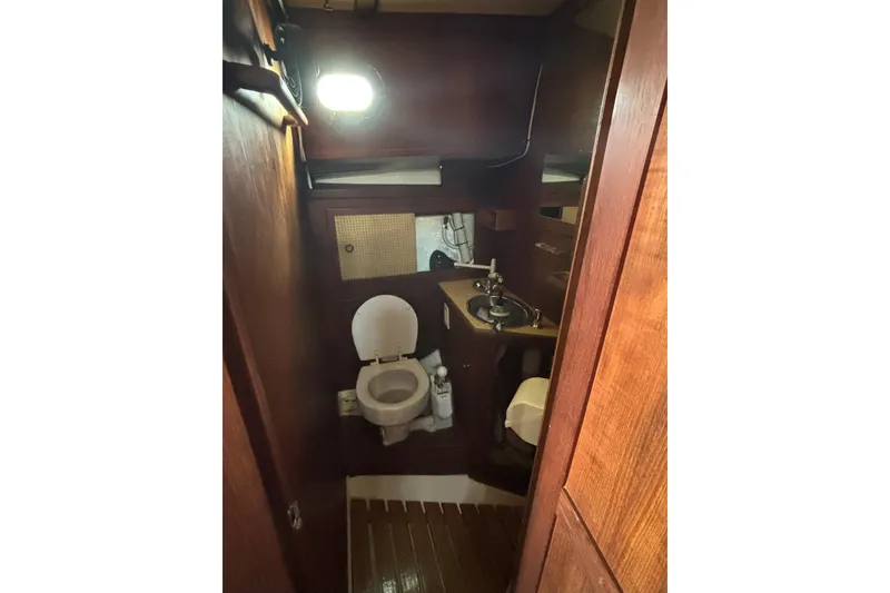 Slide: The Image of 1977 Pacific Seacraft 31 yacht bathroom with wooden interior and compact amenities. - 8