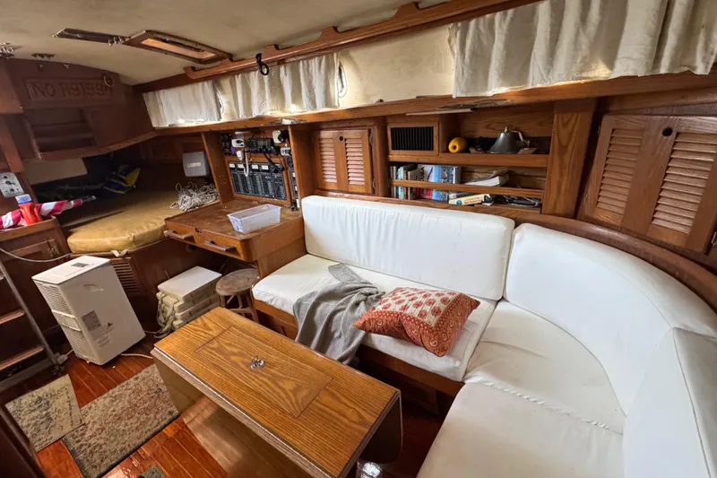 Slide: The Image of 1981 Bristol 41.1 Aft Cockpit interior with white seating, wooden accents, and nautical decor. - 11