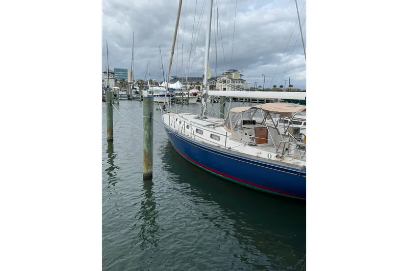 Slide: The Image of 1981 Bristol 41.1 Aft Cockpit sailboat docked in a marina under cloudy skies. - 6