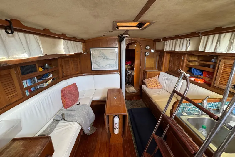 Slide: The Image of Interior of 1981 Bristol 41.1 Aft Cockpit sailboat with cozy seating and wooden finishes. - 14