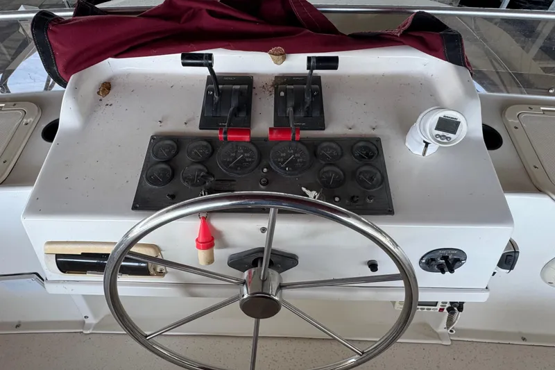 Slide: The Image of 1993 Gibson 44 Cabin Yacht helm with steering wheel and control panel. - 60