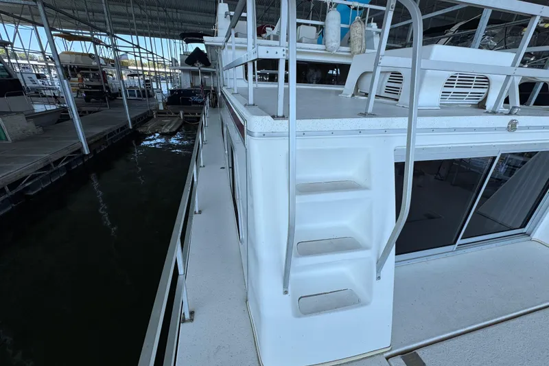Slide: The Image of 1993 Gibson 44 Cabin Yacht docked, featuring exterior stairs and upper deck view. - 41