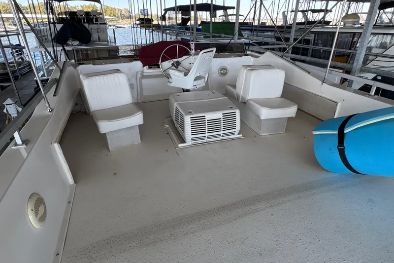 Slide: The Image of 1993 Gibson 44 Cabin Yacht deck with seating and steering wheel, docked in marina. - 57