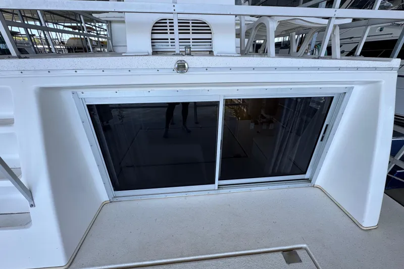 Slide: The Image of 1993 Gibson 44 Cabin Yacht with sliding glass door and upper deck seating area. - 65