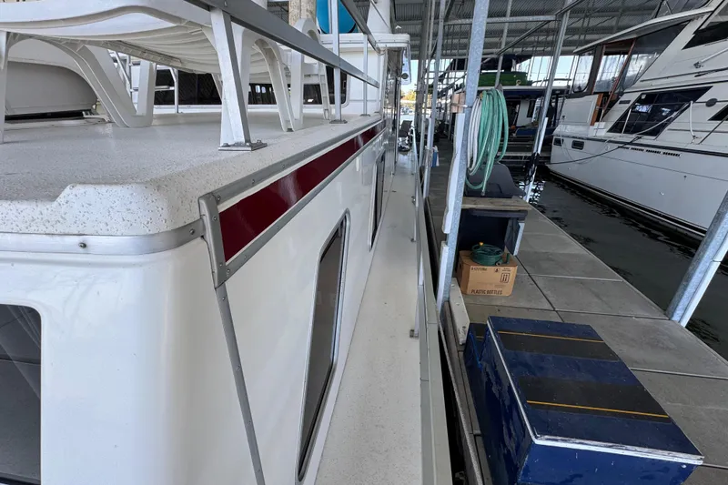 Slide: The Image of 1993 Gibson 44 Cabin Yacht docked, showing side view with deck and marina surroundings. - 67