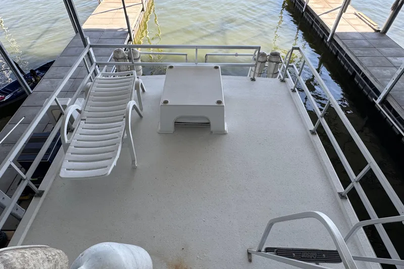 Slide: The Image of 1993 Gibson 44 Cabin Yacht deck with lounge chair and water view. - 56