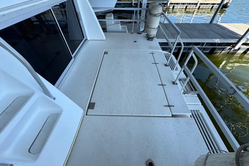 Slide: The Image of 1993 Gibson 44 Cabin Yacht deck with railing and dockside view. - 42