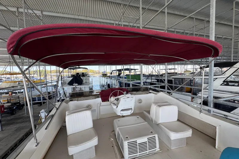 Slide: The Image of 1993 Gibson 44 Cabin Yacht with red canopy, docked in a marina. - 63