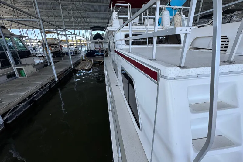 Slide: The Image of 1993 Gibson 44 Cabin Yacht docked in a covered marina. - 64