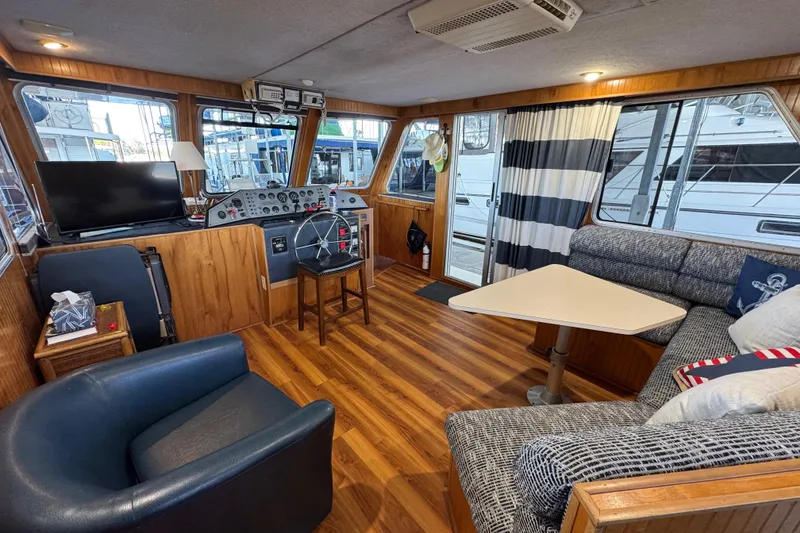 Slide: The Image of Interior of 1993 Gibson 44 Cabin Yacht with helm, seating, and striped curtains. - 34