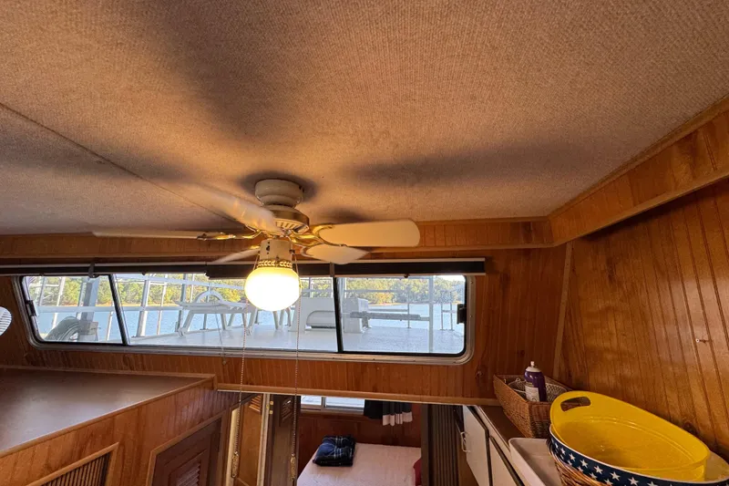 Slide: The Image of Interior of 1993 Gibson 44 Cabin Yacht with ceiling fan and wooden paneling. - 22