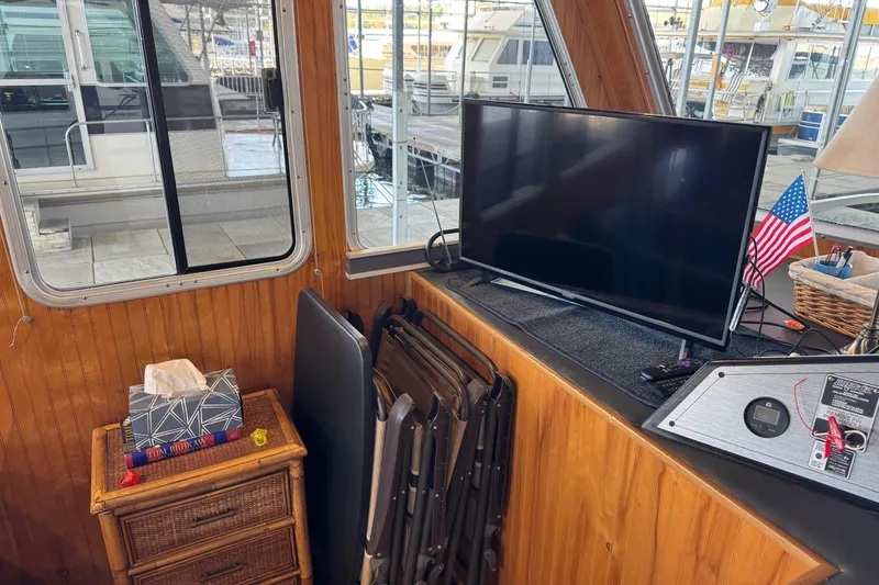 Slide: The Image of Interior of 1993 Gibson 44 Cabin Yacht with TV, American flag, and wicker furniture. - 18